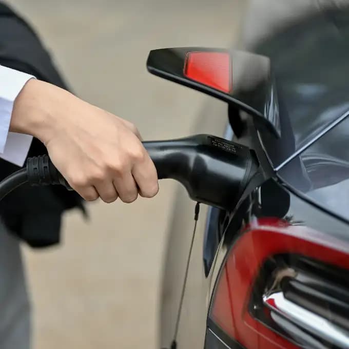 Tesla laadpaal installatie - hand die connector inplugt